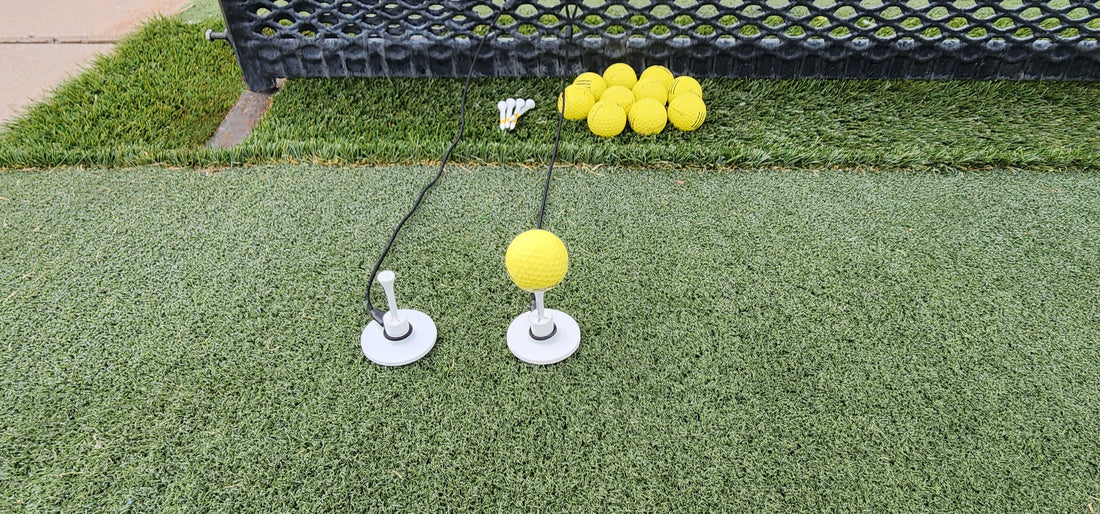 Tee Leashes — blog image — range setup with two Tee Leashes and one range ball on wood tee in rubber tee with durable elastic cords attached to range basket on turf