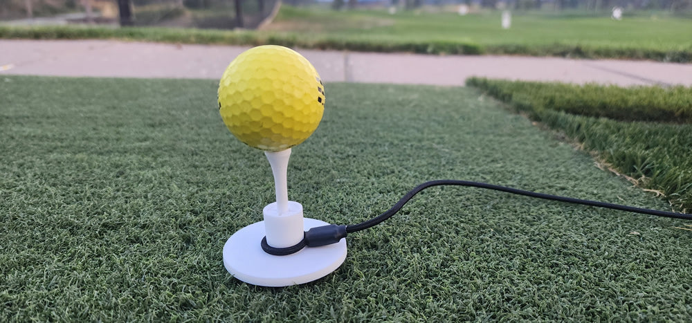 Tee Leash TL-O1 Original — product image — close-up of rubber tee with durable elastic cord on driving range turf