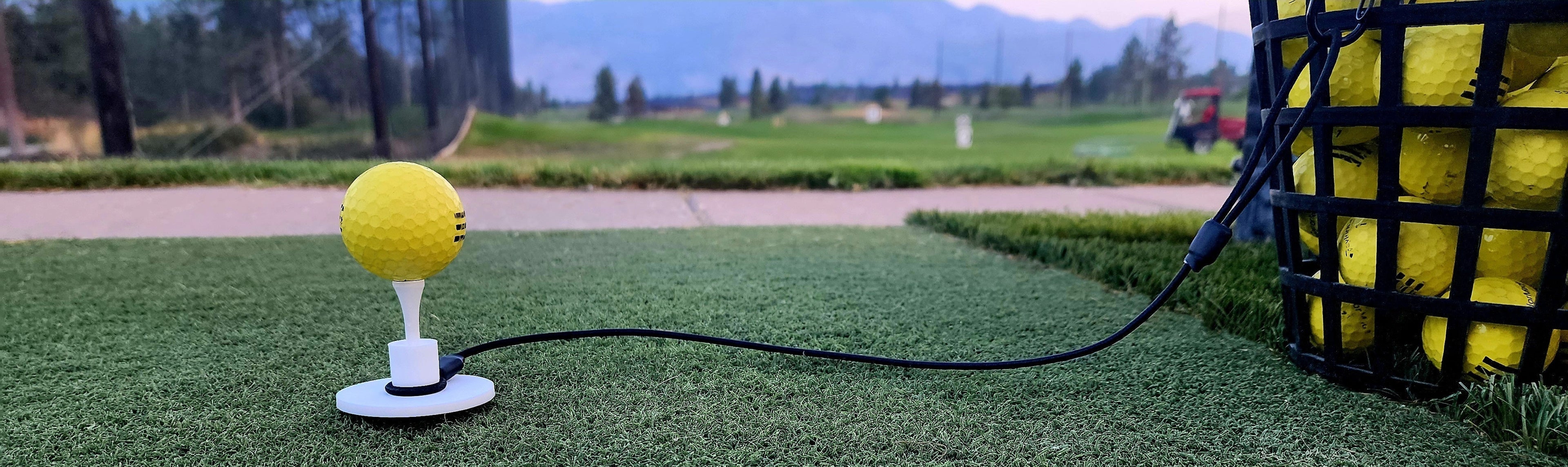 Tee Leashes — hero image — range setup with range ball on wood tee in rubber tee with durable elastic cord and s-clip attached to range basket on turf