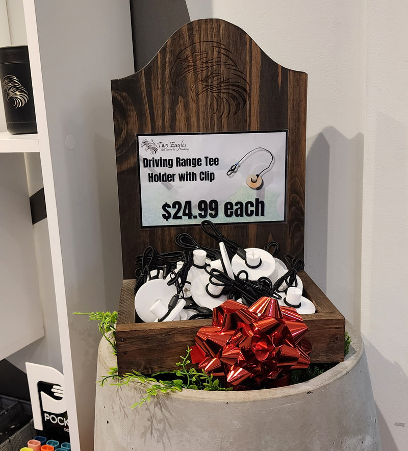 Tee Leashes, homepage, product displayed in dark wood tray with $24.99 sign and Christmas bow at Two Eagles Golf Pro Shop